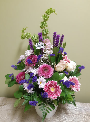 Bel arrangement floral funéraire dans les tons de rose et violet