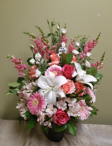 Bel arrangement floral funéraire chic dans les tons de rose et blanc