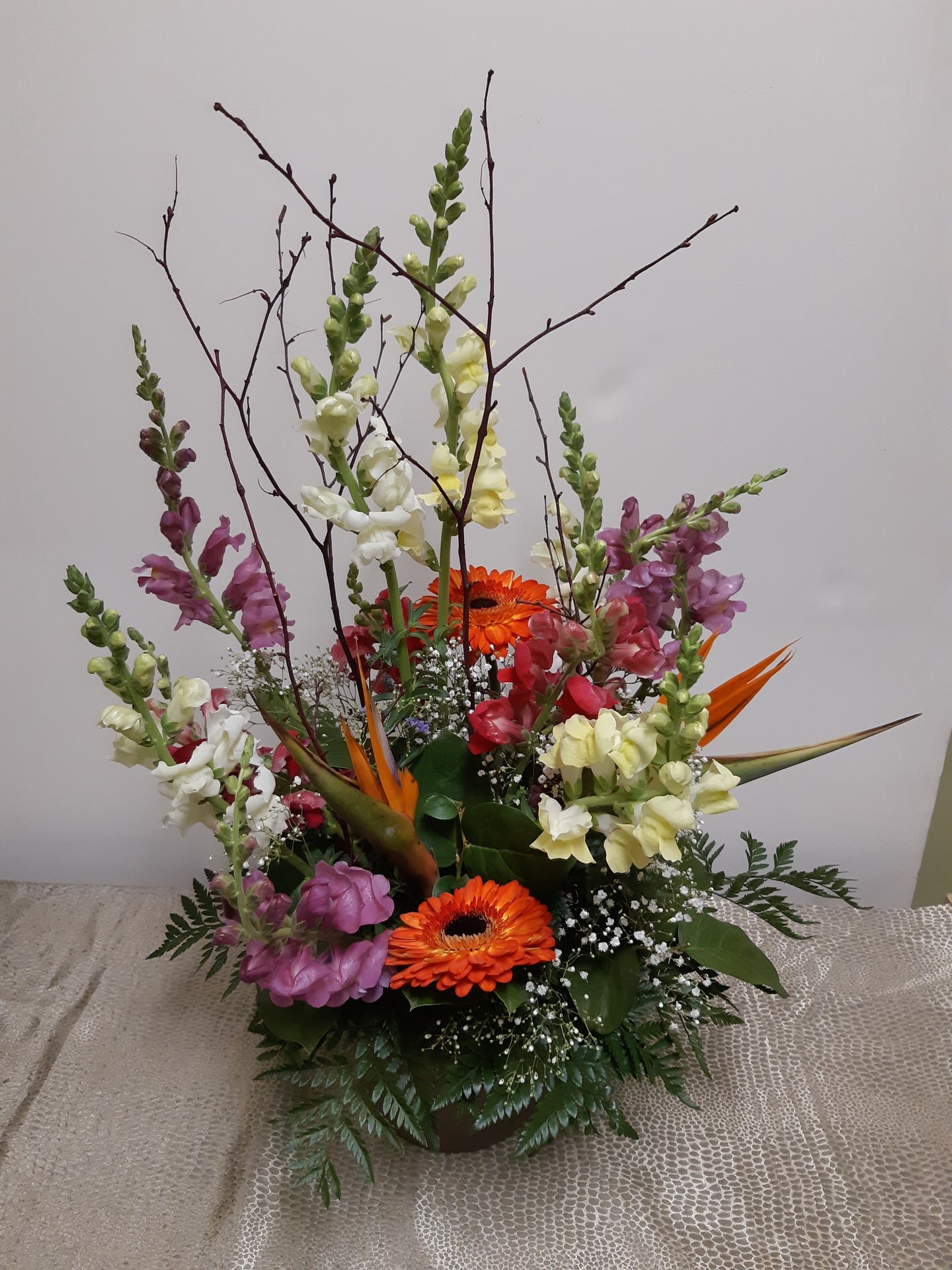 Arrangement floral funéraire coloré et bien balancé