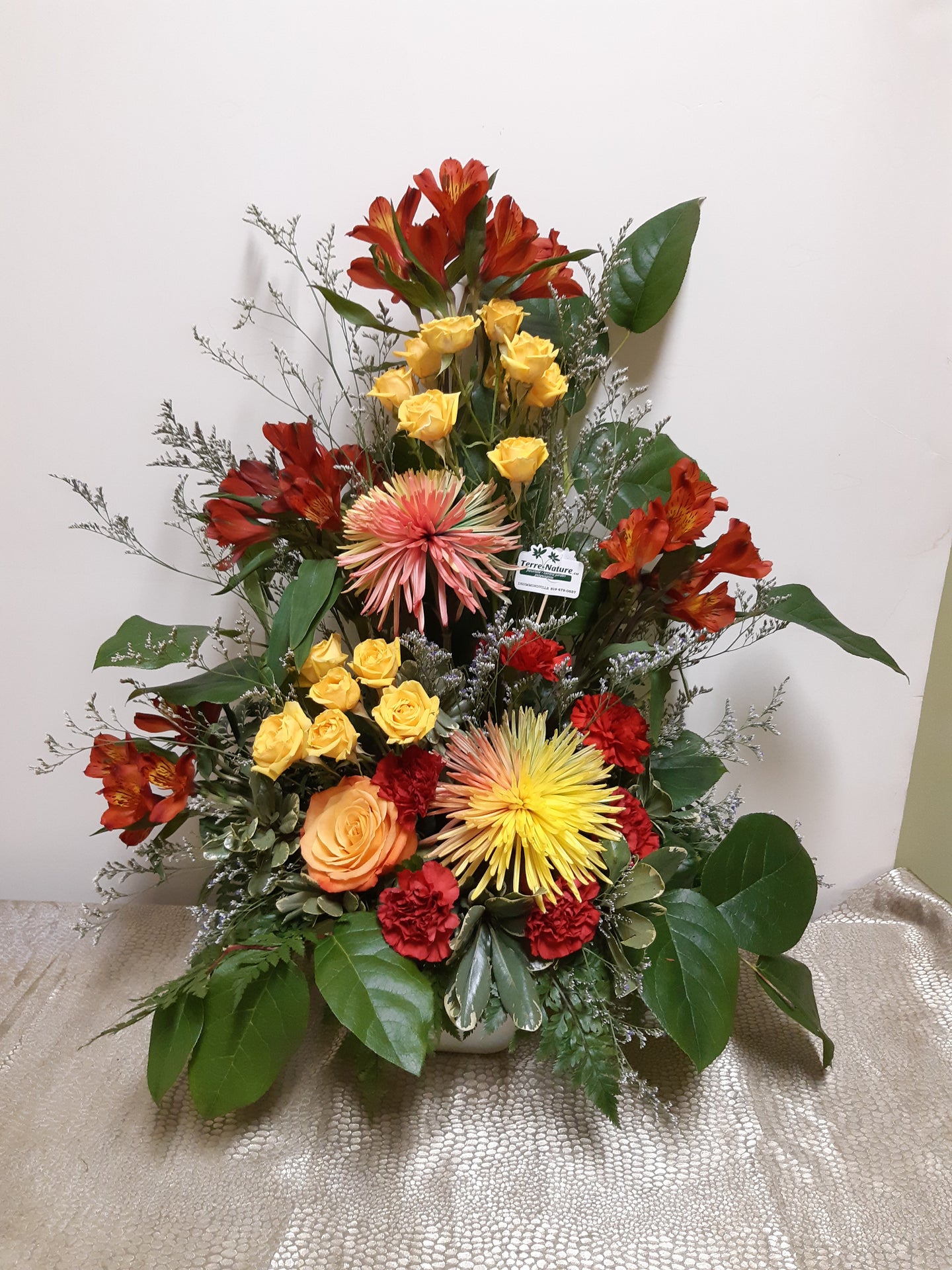 Arrangement floral funéraire dans les tons chauds