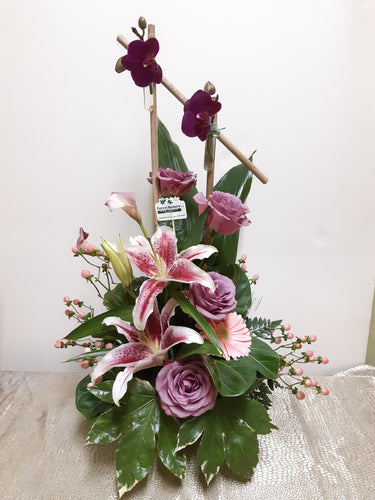Arrangement floral funéraire dans les tons de lilas et rose