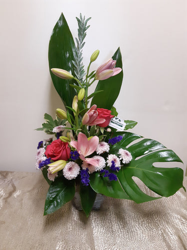 Arrangement floral funéraire dans les tons de rose et violet