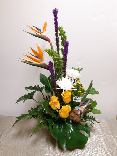 Arrangement floral funéraire décoré d'un oiseau