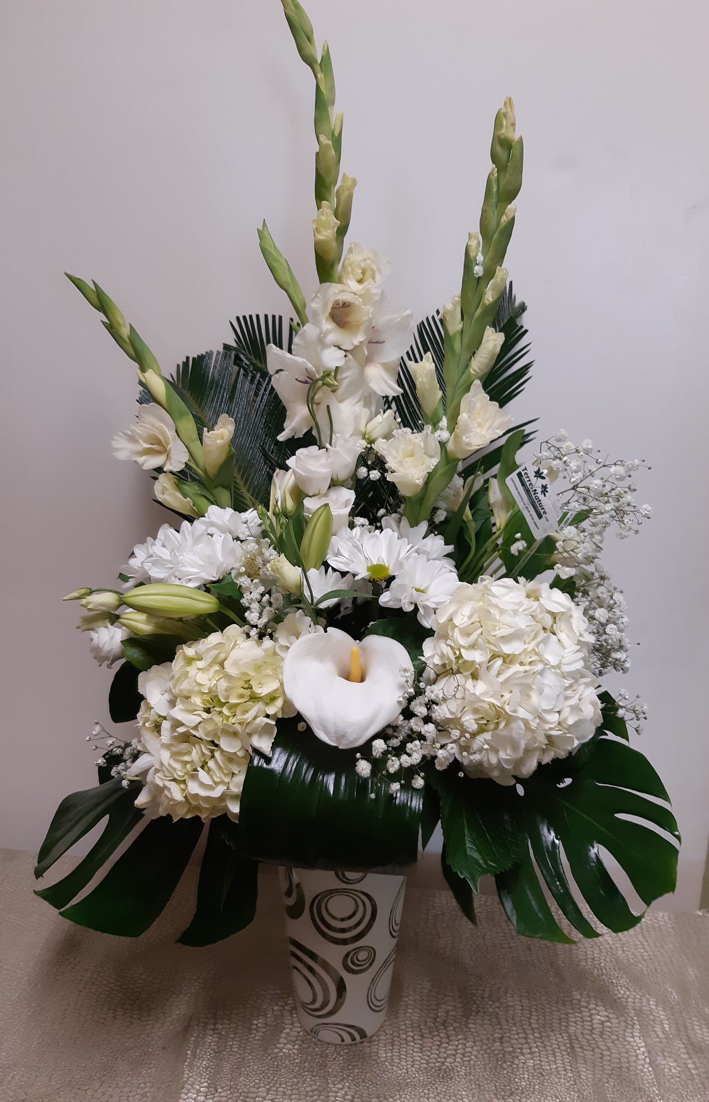 Arrangement floral funéraire élégant dans les tons de blanc