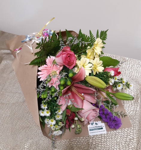 Bouquet de fleurs attaché et emballé dans les tons de rose, jaune et violet