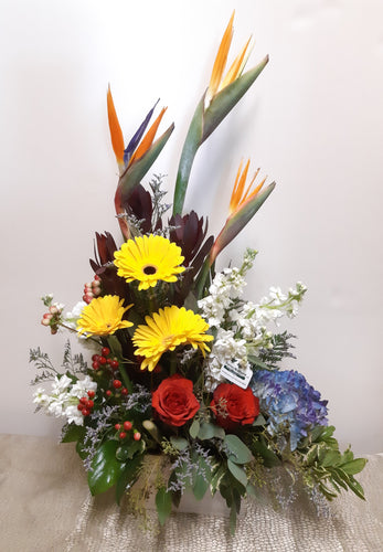 Arrangement floral funéraire en hauteur dans les tons de jaune, orange et bleu