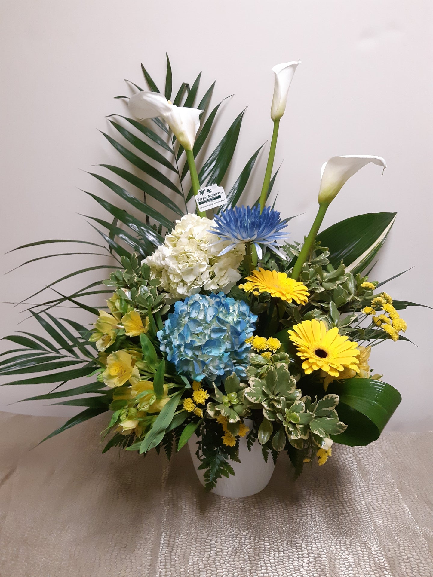 Corbeille funéraire dans les tons de blanc, bleu et jaune