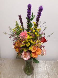 Arrangement de fleurs des champs dans les tons de rose, orange et jaune