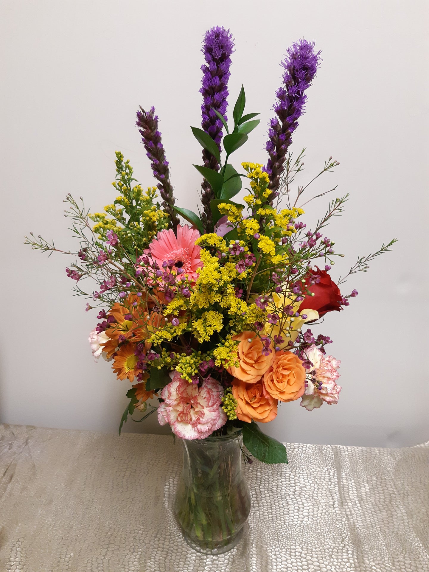Arrangement de fleurs des champs dans les tons de rose, orange et jaune